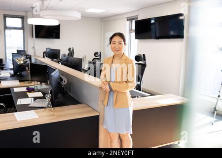 Happy asian businesswoman looking at camera in office Stock Photo