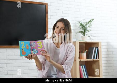 Happy female English teacher giving lesson in elementary school Stock Photo