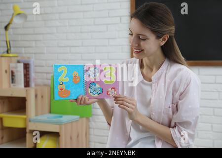 Happy female English teacher giving lesson in elementary school Stock Photo