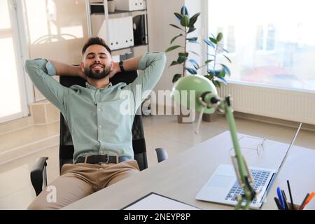 Businessman relaxing in office chair at workplace Stock Photo
