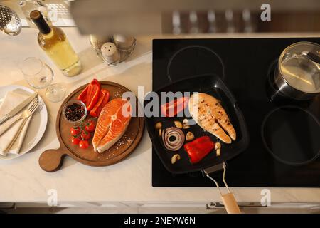 Grill pan with delicious salmon steaks on stove in kitchen Stock Photo -  Alamy