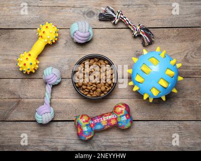 Flat lay composition with different pet toys and feeding bowl on wooden background Stock Photo