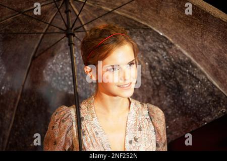 Cast member Emma Watson takes shelter under an umbrella as she poses ...