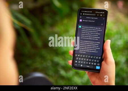 February 5, 2023, Mirissa, Sri Lanka. Using OpenAI chatGPT on phone. Woman chats with artificial intelligence. Person tests neural network language Stock Photo