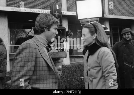 Charlotte Ford Niarchos, daughter of auto industrialist Henry Ford II, talks with Ryan O'Neal on movie location at Mt. Sinai Hospital in New York on Jan. 26, 1970. Mrs. Niarchos in making her screen debut in 'Love Story,' playing the part of a receptionist. O'Neal stars in the film. (AP Photo/Jack Harris)
