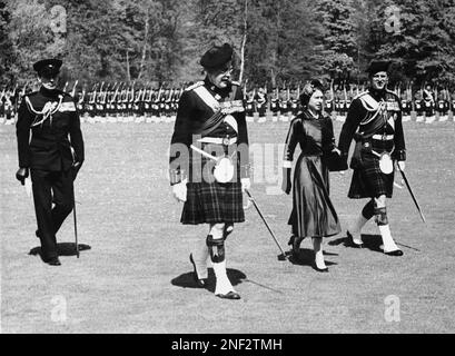 Queen Elizabeth II, during a colorful ceremony at Balmoral Palace in Scotland, presented New Colors to the 1st Battalion of the Queen's own Cameron Highlanders, May 30, 1955. The Duke of Edinburgh, right, was dressed in full ceremonial garb and carried the silver-hilted Claymore the Camerons presented him at Luneburg, Germany. At left is Maj. Gen. D.N. Wimberly. The group are walking to the saluting base for the ceremony of New Colors. The Queen's children, Prince Charles and Princess Anne, watched the military pageantry from a castle window. (AP Photo)