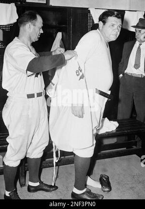 Here's Babe Ruth, sliding into his Brooklyn Dodgers uniform at Ebbets Field  in New York to take up his duties as the new Dodgers coach, June 19, 1938.  Manager Burleigh Grimes helps