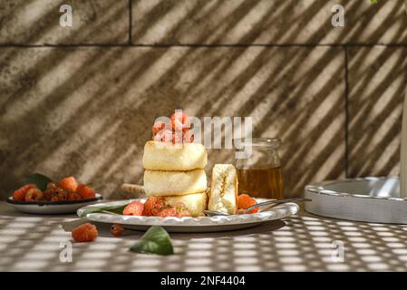 cottage cheesecakes with raspberries and currants. cheesecakes are stacked and decorated with berries, one cheesecake in a section Stock Photo