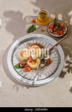 cottage cheesecakes with raspberries and currants. cheesecakes are stacked and decorated with berries, one cheesecake in a section Stock Photo