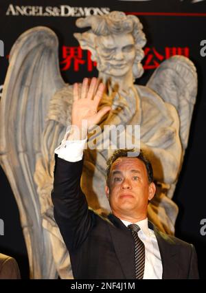 U.S. actor Tom Hanks waves a baseball cap of the Yomiuri Giants at  spectators after throwing the first pitch before the start of Japan's  professional baseball game between the Giants and the
