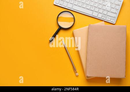 Books, pen, magnifier and keyboard on color background. World Poetry Day celebration Stock Photo