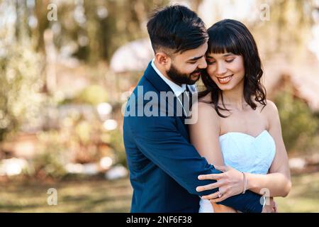 I knew I had to choose you. an affectionate young newlywed couple embracing each other while standing outdoors on their wedding day. Stock Photo