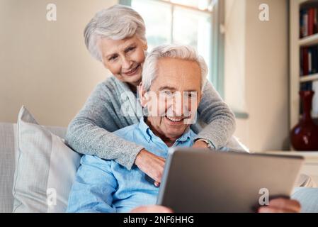 Stay connected and enjoy a better quality of life. a senior couple using a digital tablet together in their living room at home. Stock Photo