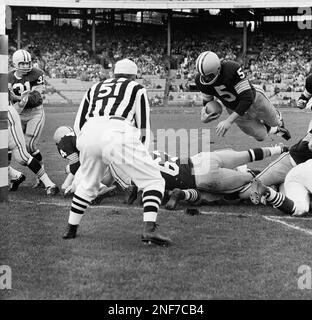 FILE - In this Oct. 7, 1962, file photo, Green Bay Packers halfback Paul  Hornung (5) carries the Detroit Lions, including Roger Brown (76, to the  right of Hornung), during the second