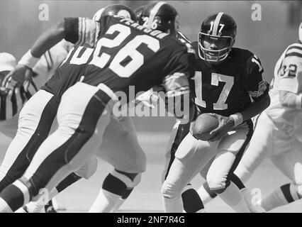 Miami Dolphins linebacker A.J. Duhe (77) leans on Pittsburgh Steelers  quarterback Terry Bradshaw and sacks him during the second quarter of game  in Miami's Orange Bowl Stadium, Thursday, Sept. 11, 1981, Miami