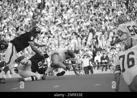 Washington Redskins' quarterback Bill Kilmer (17) is hit by Miami Dolphins'  Doug Swift (59), left, just after getting off pass which has intercepted by  Dolphins' Nick Buoniconti (85), right, during the Super