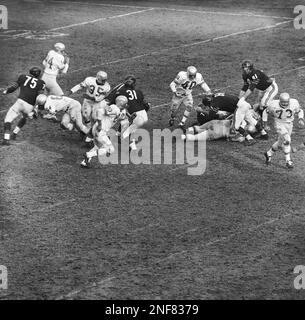 Detroit Lions back Howard Cassady (40) shoots toward the big hole in the  Chicago Bears defense in the third quarter, Dec. 14, 1959, Chicago, Ill.  The Bears guard Bill George (61) and end Doug Atkins (81) moved over to  bring him down. He gained only two