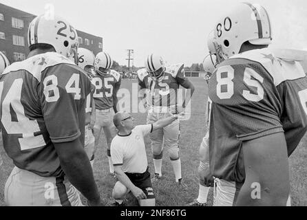 Willie Davis of the Green Bay Packers, center left, working with the  defensive team of the College All-Stars, is framed by muscular arm of  Anthony McGee of Bishop University during a workout