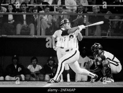 Phillies left fielder Greg Luzinski, center, follows through on a