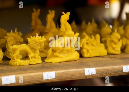 Stall with festive wax candles at the Street Christmas Market in Gdansk, Poland. The market is an annual tradition and a part of celebration Wooden wick candles. Handmade candle from paraffin and soy wax in different shapes. Stock Photo