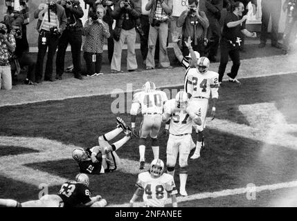 Oakland Raiders quarterback Ken Stabler (12) is caught in the act of  scoring game winning touchdown against the New England Patriots on  Saturday, Dec. 20, 1976 in Oakland. Arriving on the scene