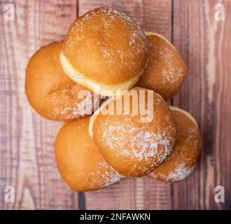 Austrian and german donuts or krapfen. Berliner with cream. On wooden background. Selective focus. Stock Photo