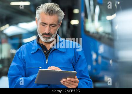 mechanic working with digital tablet Stock Photo
