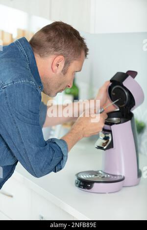 a man fixing coffee machine Stock Photo