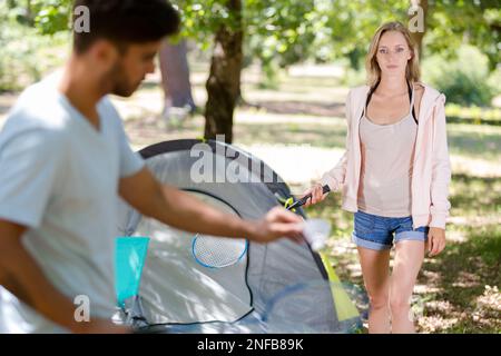 happy friends playing badminton outdoors Stock Photo