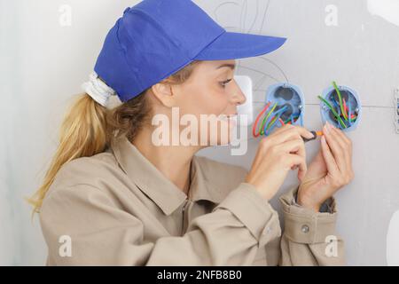 happy female electrician fixing socket electricity Stock Photo