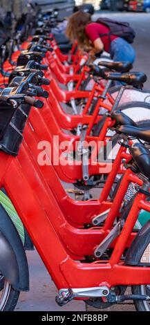 Detail of the handlebars and pedals of shared rental red bicycles parked in a row on a street in the city of Barcelona. Stock Photo