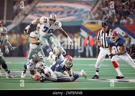 Miami Dolphins running back Terry Kirby (43) fumbles under pressure from  Dallas Cowboys Brock Marion (31), Bill Bates (40) and Leon Lett (78) in the  first quarter in Irving, Texas, Nov. 25