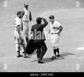 Yankee manager Yogi Berra (8) signals the bullpen for a new hurler