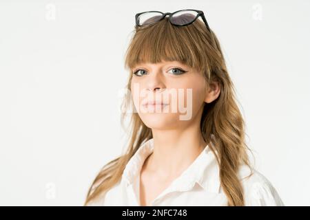 A woman wearing sunglasses and long, wispy bangs stands in a casual pose Stock Photo