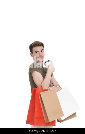 Young caucasian man holding shopping bags and coffee, isolated. Stock Photo