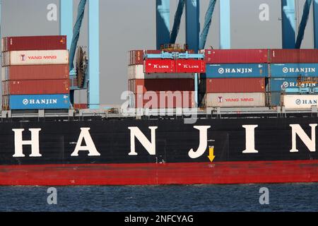 A crane unloads a container from a ship owned by Hanjin Shipping