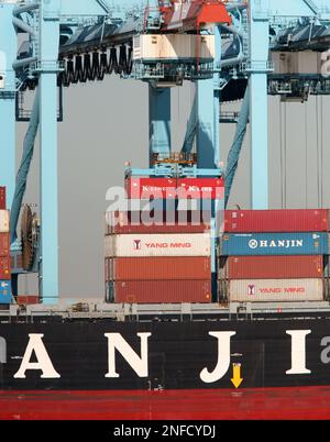 A crane unloads a container from a ship owned by Hanjin Shipping