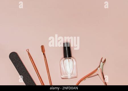 Manicure tools, file and transparent nail polish on pink background, flat lay Stock Photo