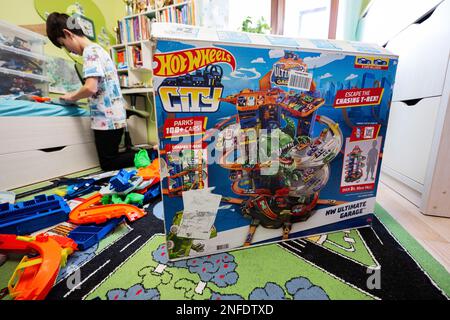 Ternopil, Ukraine - February, 2023: Boy unboxing Hot Wheels City Ultimate Garage, play in children room. Stock Photo