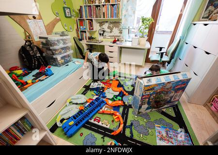 Ternopil, Ukraine - February, 2023: Kids unboxing Hot Wheels City Ultimate Garage, play in children room. Stock Photo