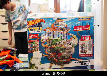Ternopil, Ukraine - February, 2023: Boy unboxing Hot Wheels City Ultimate Garage, play in children room. Stock Photo