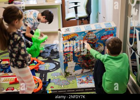 Ternopil, Ukraine - February, 2023: Kids unboxing Hot Wheels City