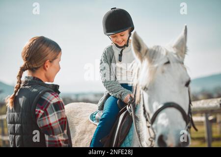 Learning, hobby and girl on a horse with a woman for fun activity in the countryside of Italy. Happy, animal and teacher teaching a child horseback Stock Photo