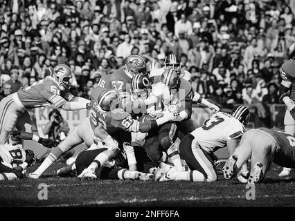 Washington Redskins running back John Riggins (44) with a host of Detroit  Lions defenders hanging on makes a gain in NFC play-off action between the  Lions and Skins, Saturday, Jan. 8, 1983