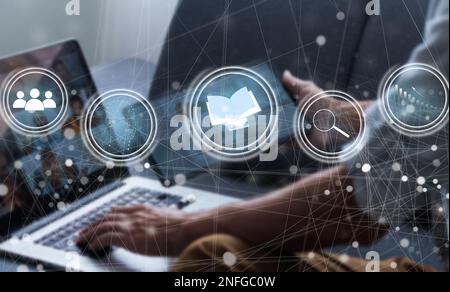 Document Management System (DMS) being setup by IT consultant working on laptop computer in office with document directory. Software for archiving Stock Photo