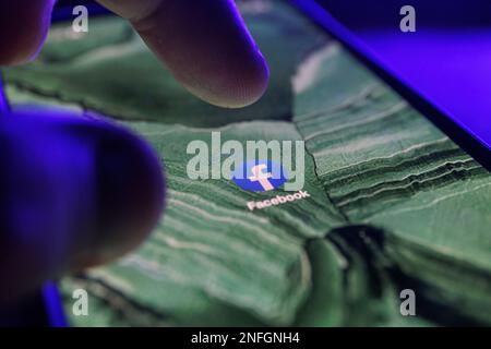A close-up shot of the Facebook app icon, as seen on the screen of a ...