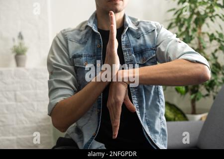 Man Using Sign Language To Communicate At Home Stock Photo