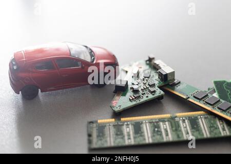 Toy cars on an electronic board with integrated circuits. The shortage of microchips and semiconductors creates a shortage of new cars. semiconductor Stock Photo