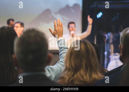 Hands in the air of people who praise God at church service Stock Photo