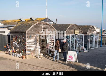 A couple outside shops in Amble harbour village, Northumberland, England, UK Stock Photo